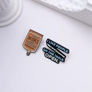 Medical enamel pins set featuring IV bag and scalpel designs on a white stone pedestal