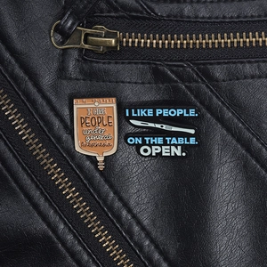 Détail de badges médicaux amusants avec scalpel et sacs de perfusion sur cuir noir