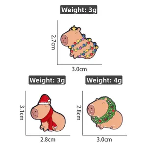 Detailed view of three Christmas capybara enamel pins with festive light and hat accents
