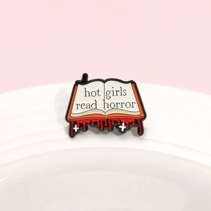Minimalist open book metal brooch with hot girls read horror text and red drips