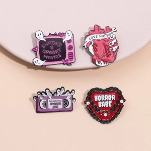 Set of four spooky enamel pins featuring a vintage TV, anatomical heart, and purple cassette