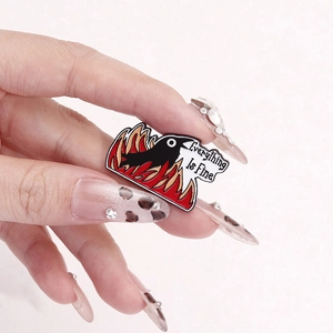 Creative enamel pin featuring a black crow in fire with 'Everything Is Fine' meme design