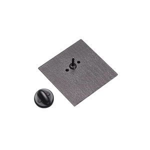 Close-up of matte black metal brooch backing with pin and secure rubber clutch