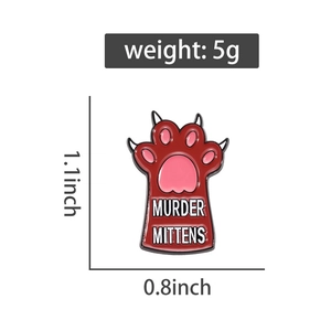 Detail view of red cat paw enamel pin with Murder Mittens text and 1.1x0.8 inch dimensions
