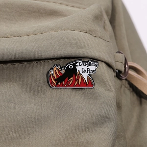 Creative black crow fire enamel pin with Everything Is Fine slogan on canvas bag