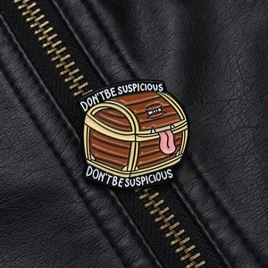 Detail einer Comic-Schatztruhe-Emaille-Anstecknadel auf schwarzer Lederjacke mit Textur