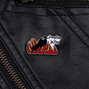 Detail of fire bird enamel pin on black leather jacket with Everything Is Fine text