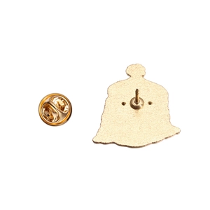 Detail of gold metal pin back with butterfly clutch fastener and textured finish