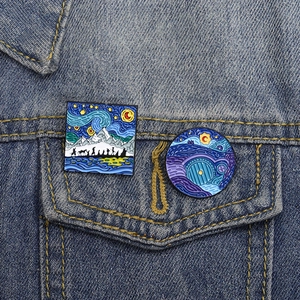 Starry night style Lord of the Rings enamel pins set on a blue denim jacket pocket