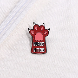 Detail of Murder Mittens cat paw enamel pin featuring pink toe beans on white canvas