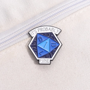Detail of d20 blue enamel pin with It's Probably Fine slogan on white canvas bag