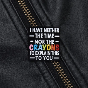 Détail macro d'une broche en émail avec citation drôle sur revers en cuir noir