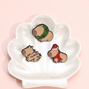 Three-piece Christmas capybara enamel pin set with festive hat and wreath on shell tray