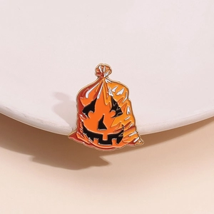 Detail of Halloween enamel brooch showing an orange pumpkin bag with golden alloy edges