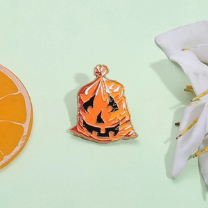 Spilla di Halloween a forma di sacchetto di zucca in smalto su sfondo verde elegante