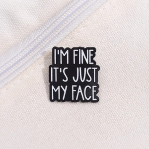 Macro view of a rectangular black enamel pin with a witty text on a white canvas bag