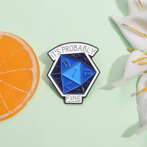 "IT'S PROBABLY FINE" blue d20 dice enamel pin on light green decorative surface
