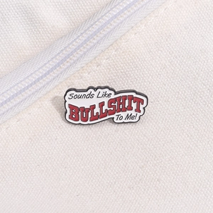 Detail of an enamel speech bubble pin with funny quote attached to a white canvas bag