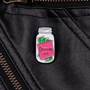 Detail of Douchebag Jar enamel pin with green bills on a black leather jacket texture