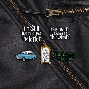 Detailed close-up of magic-themed enamel pins on a black leather jacket background