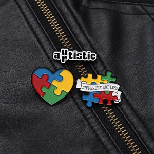 Detailed view of colorful puzzle enamel pins on a black leather jacket for autism awareness
