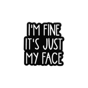 Minimalist black enamel pin badge with white text I'M FINE IT'S JUST MY FACE cutout design