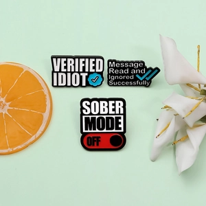Set aus drei kreativen Emaille-Pins mit humorvollen Sprüchen auf hellgrünem Grund