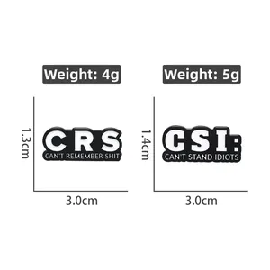 Detail view of CRS and CSI enamel pins with humorous text on polished metal alloy