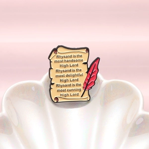 Broche en émail avec parchemin, plume rouge et citation littéraire sur coquille