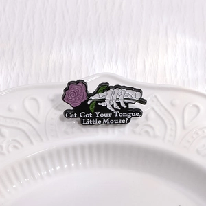 Gothic enamel pin featuring skeletal hand holding a purple rose with slogan text