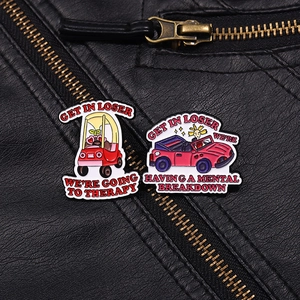 Macro detail of enamel pins with text on black leather jacket showing metal pin details