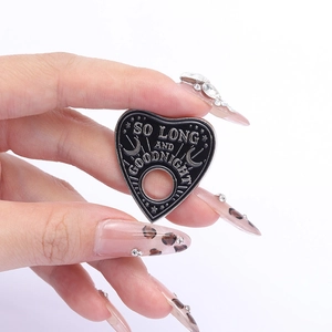 Detail of heart-shaped black enamel pin with moon stars and So Long And Goodnight text