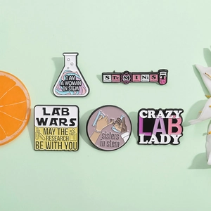 Five-piece STEM themed enamel pins featuring science laboratory flasks and feminist slogans