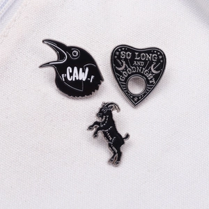 Gothic black enamel pin set featuring raven, planchette and goat with white line detail