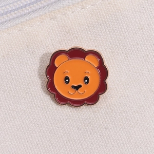 Detailed view of a cute cartoon lion enamel brooch on a beige canvas bag fabric