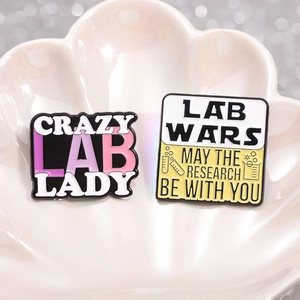 Laboratory enamel pins featuring Crazy Lab Lady and Lab Wars designs in shell tray