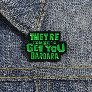 Green punk enamel pin on denim jacket featuring Night of the Living Dead movie quote
