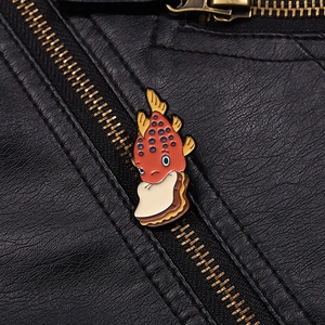 Gros plan détaillé d'une broche en émail poisson mignon sur une veste en cuir noir