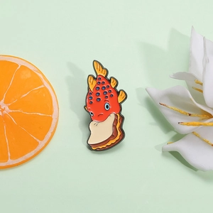 Broche en émail poisson sandwich rouge sur fond vert avec tranche d'orange et fleurs