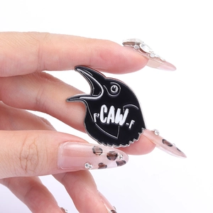 Cute enamel crow brooch with 'CAW' text in vintage metal style for clothing and bags