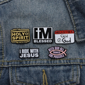 Detail view of five Christian enamel pins featuring cross icons on denim fabric