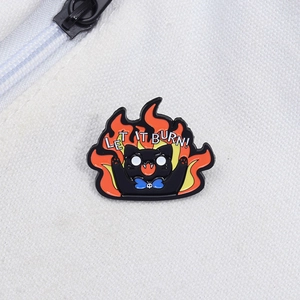 Angry black cat enamel pin with flames and 'LET IT BURN!' slogan on canvas bag
