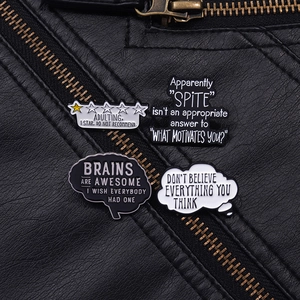 Close-up of humorous black and white enamel brain pins on a black leather jacket