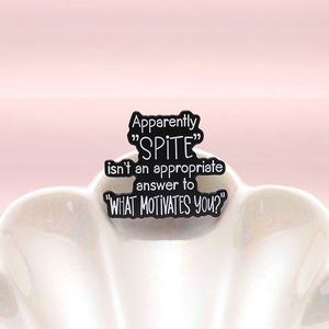 Black enamel brooch with humorous English quote on a white pearlescent shell tray