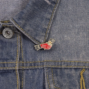 Detail van een emaille roos handspeld met Bad Seed tekst op een denim jasje