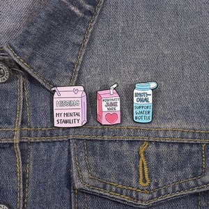 Three-piece enamel pins set with cute drink bottle motifs on denim jacket pocket
