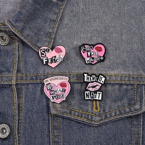 Lot de 4 broches en émail rose avec citations tendances sur une veste en jean bleu