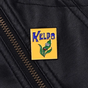 Detail of yellow Kelpo cereal enamel pin with green seaweed on a black leather jacket