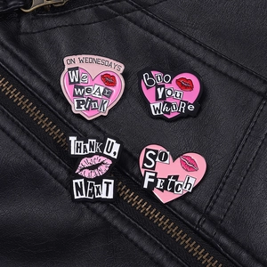 Détail de quatre épingles en émail rose sur cuir avec lèvres et citations de films