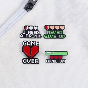 Close-up of pixel art enamel pins with gaming slogans on white canvas texture